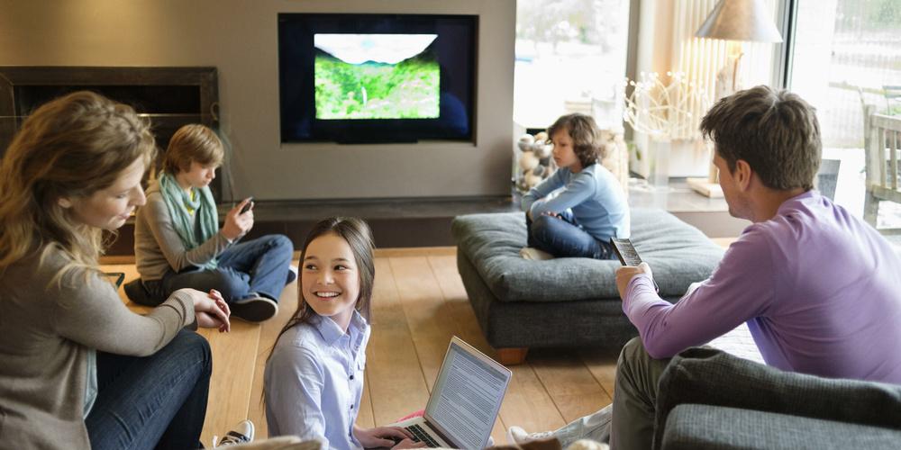 Family using electronic gadgets in a living room